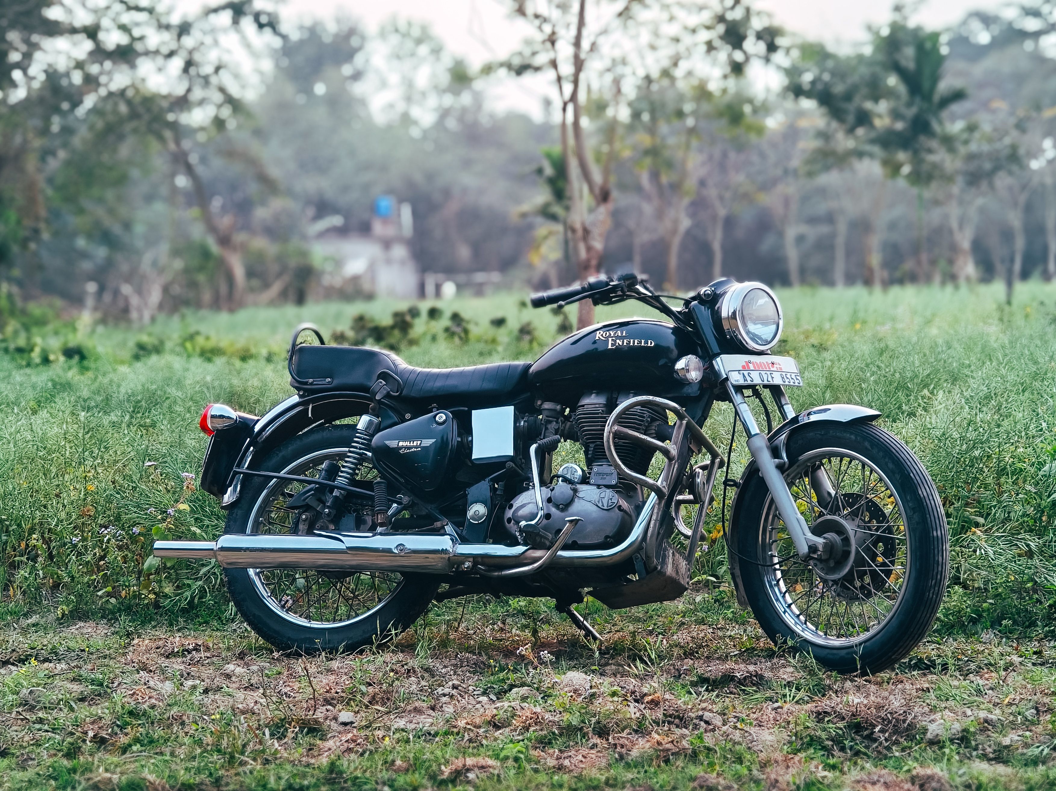 Classic Royal Enfield Motorcycle in Scenic Field · Free Stock Photo