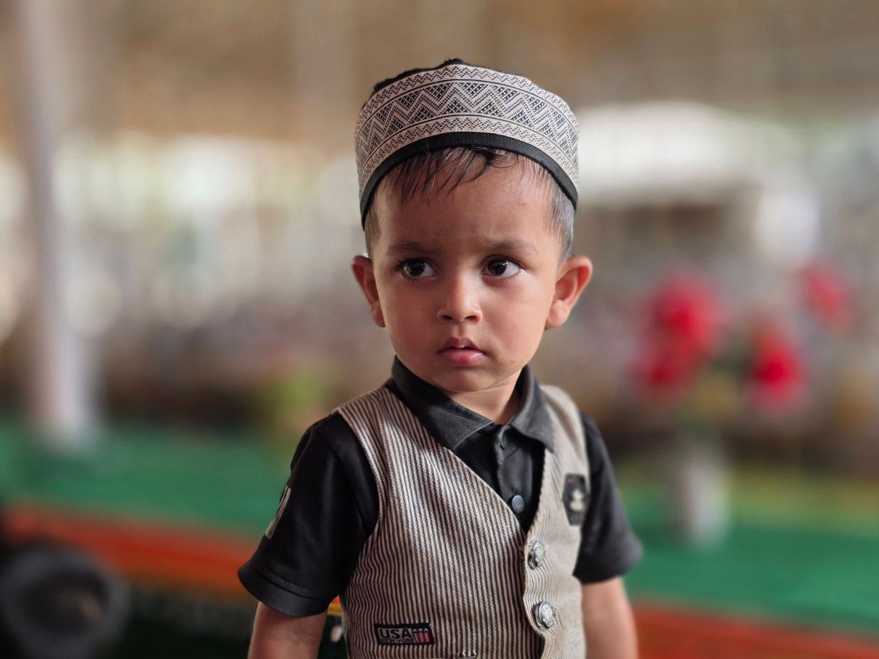 charming portrait of a young boy wearing a traditional hat dressed for