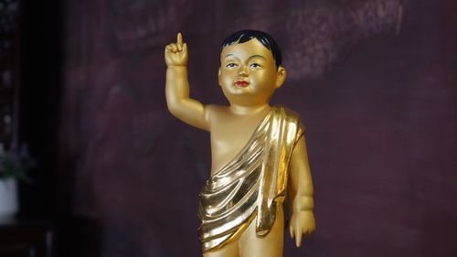 Free A golden Buddha statue in traditional robe with a hand gesture, symbolizing enlightenment. Stock Photo