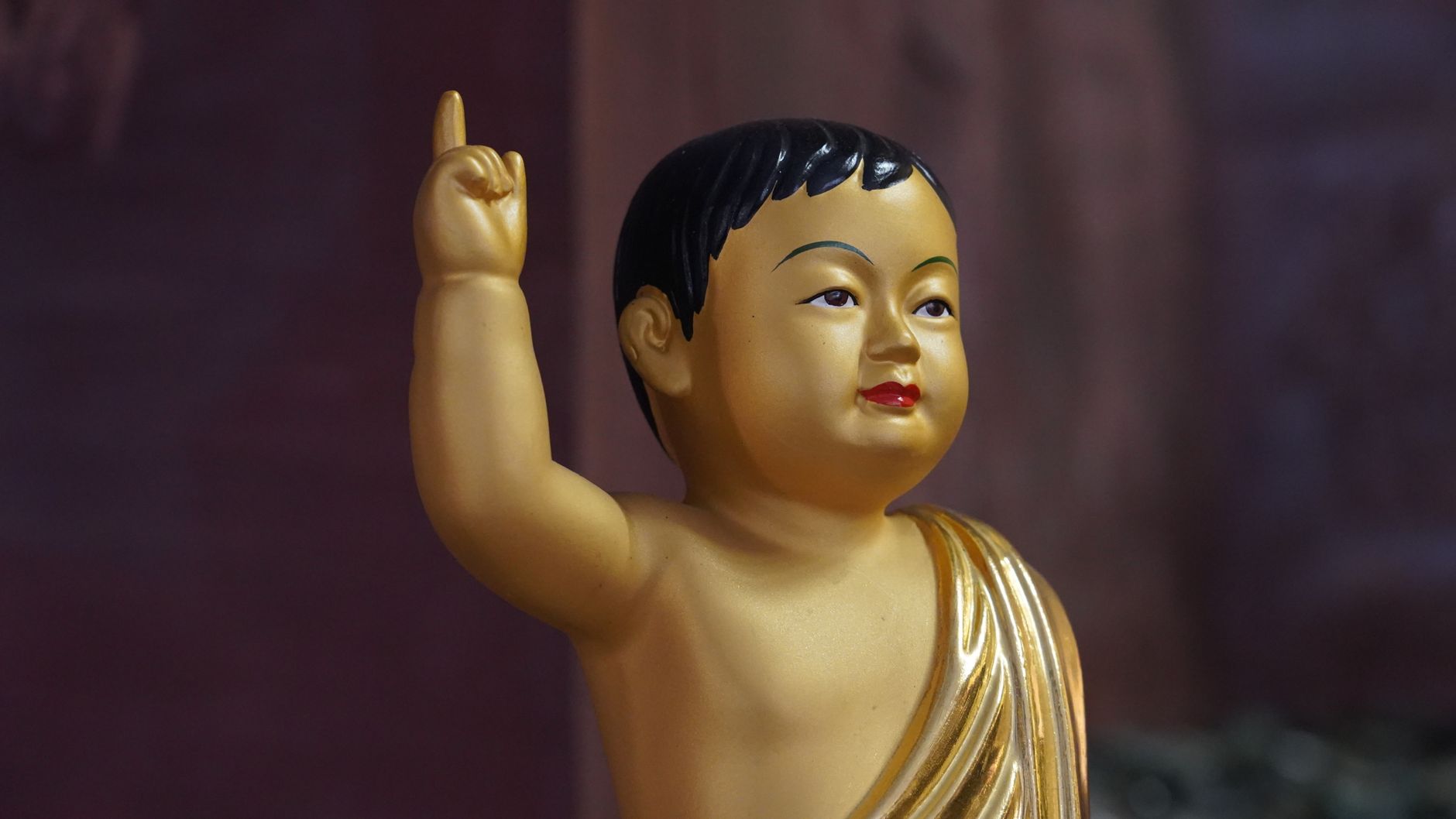 Gold statue of young Buddha raising hand, symbolizing enlightenment in Seoul.