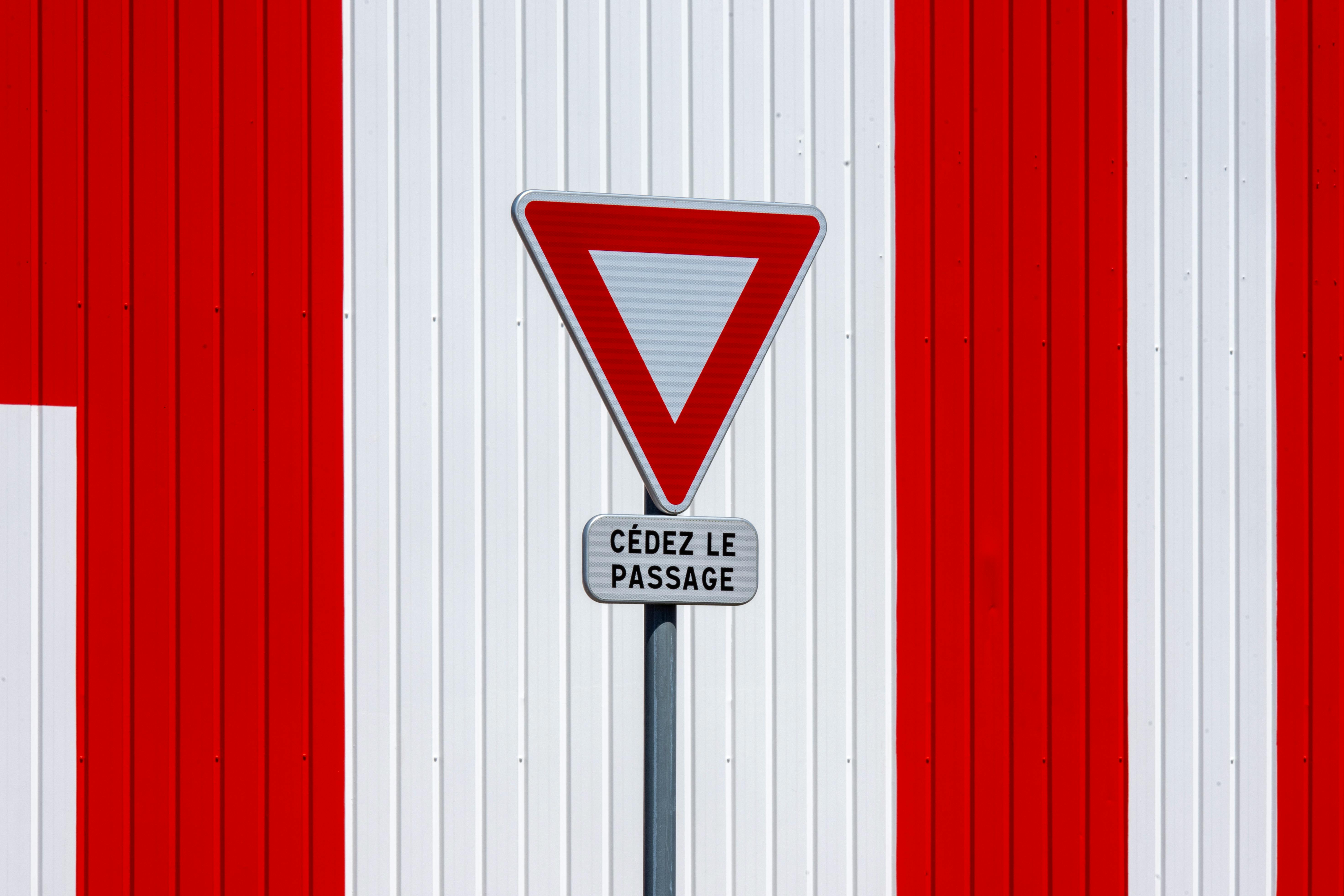 ingyenes Egy francia „Hozzáférés” tábla egy piros-fehér csíkos falon, minimalista dizájnnal. Stockfotó