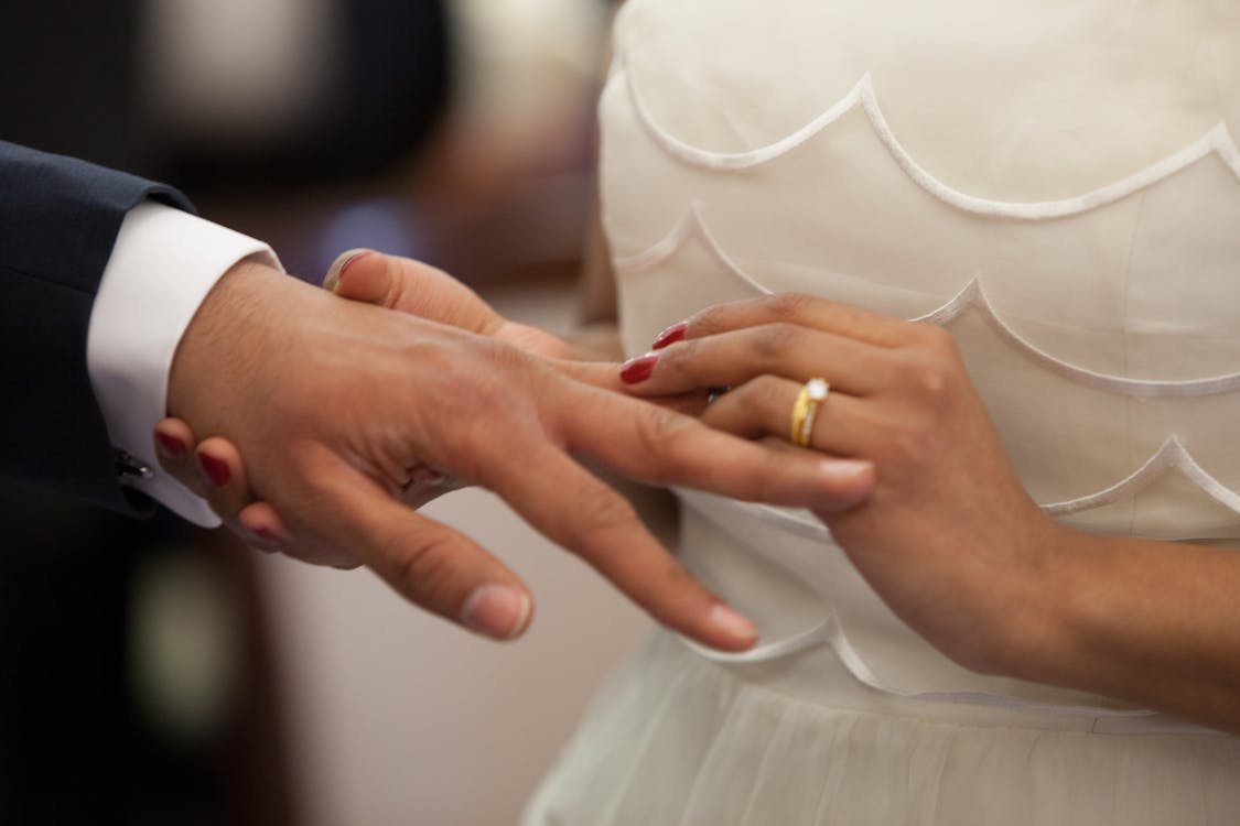 Free Bride Putting a Ring on Grooms Hand Stock Photo