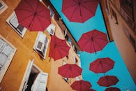 Floating Red Umbrellas Against Blue Sky