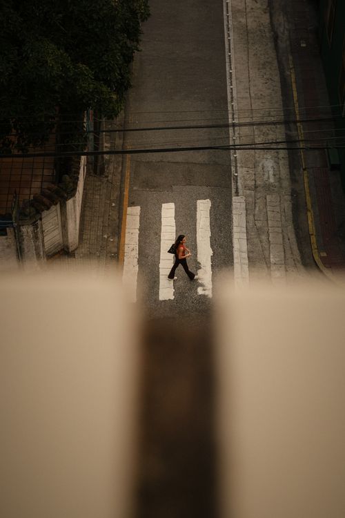 Free A person crossing an urban street in Santa Catarina, Brazil, seen from above. Stock Photo