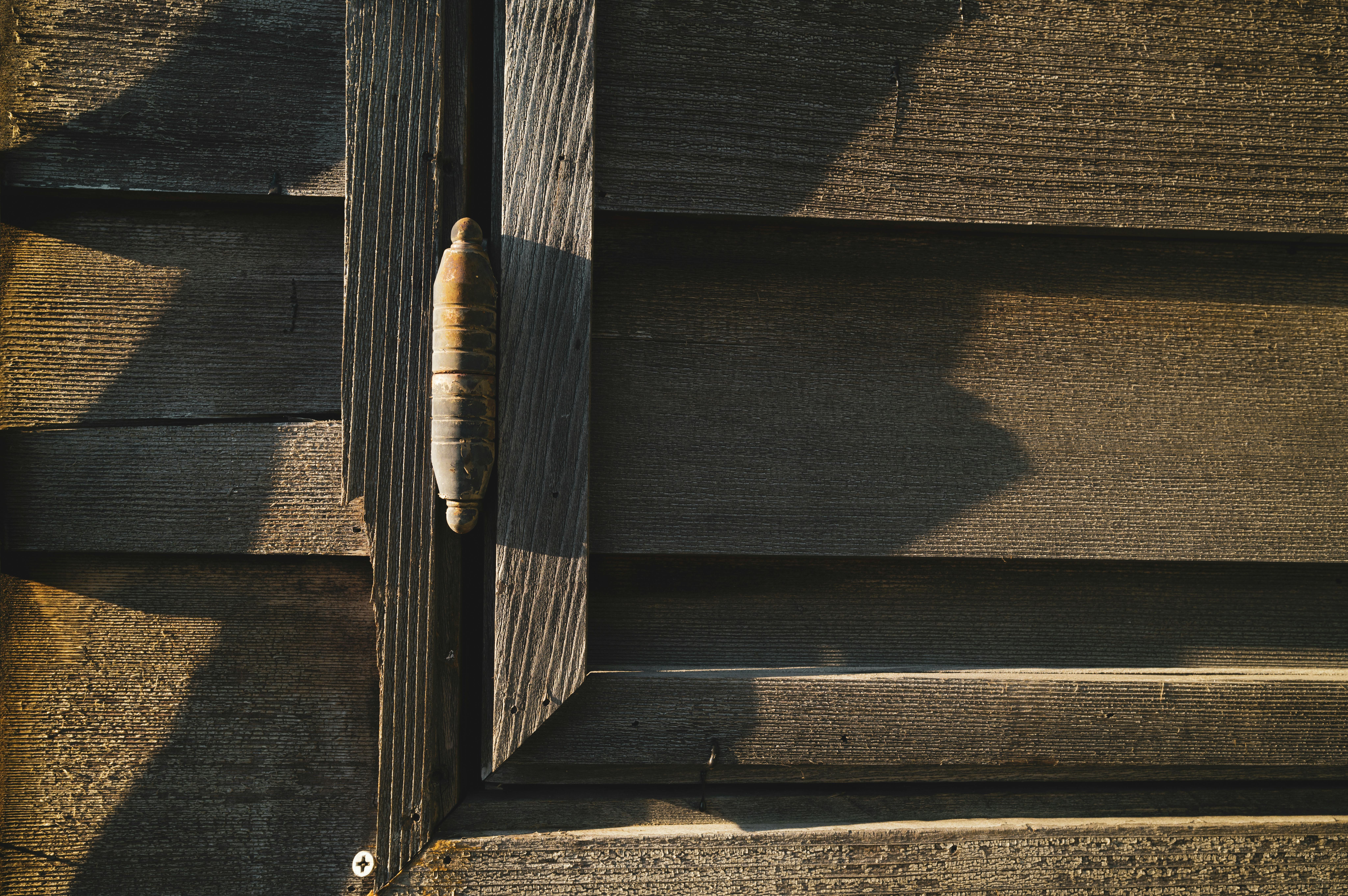 Gratis Ripresa dettagliata di una parete rustica in legno con ombre proiettate dal sole, che ne mettono in risalto la consistenza e il motivo. Foto a disposizione