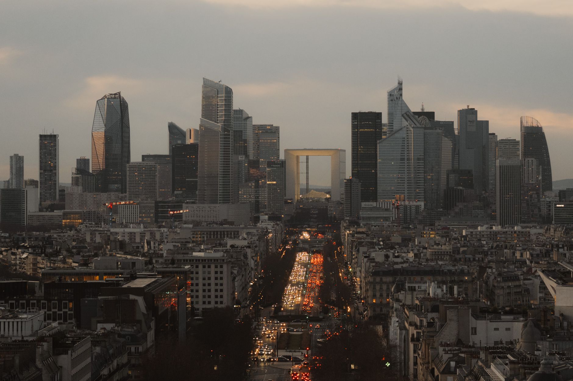 Stunning dusk view of La Défense in Paris, showcasing modern skyscrapers and urban traffic.