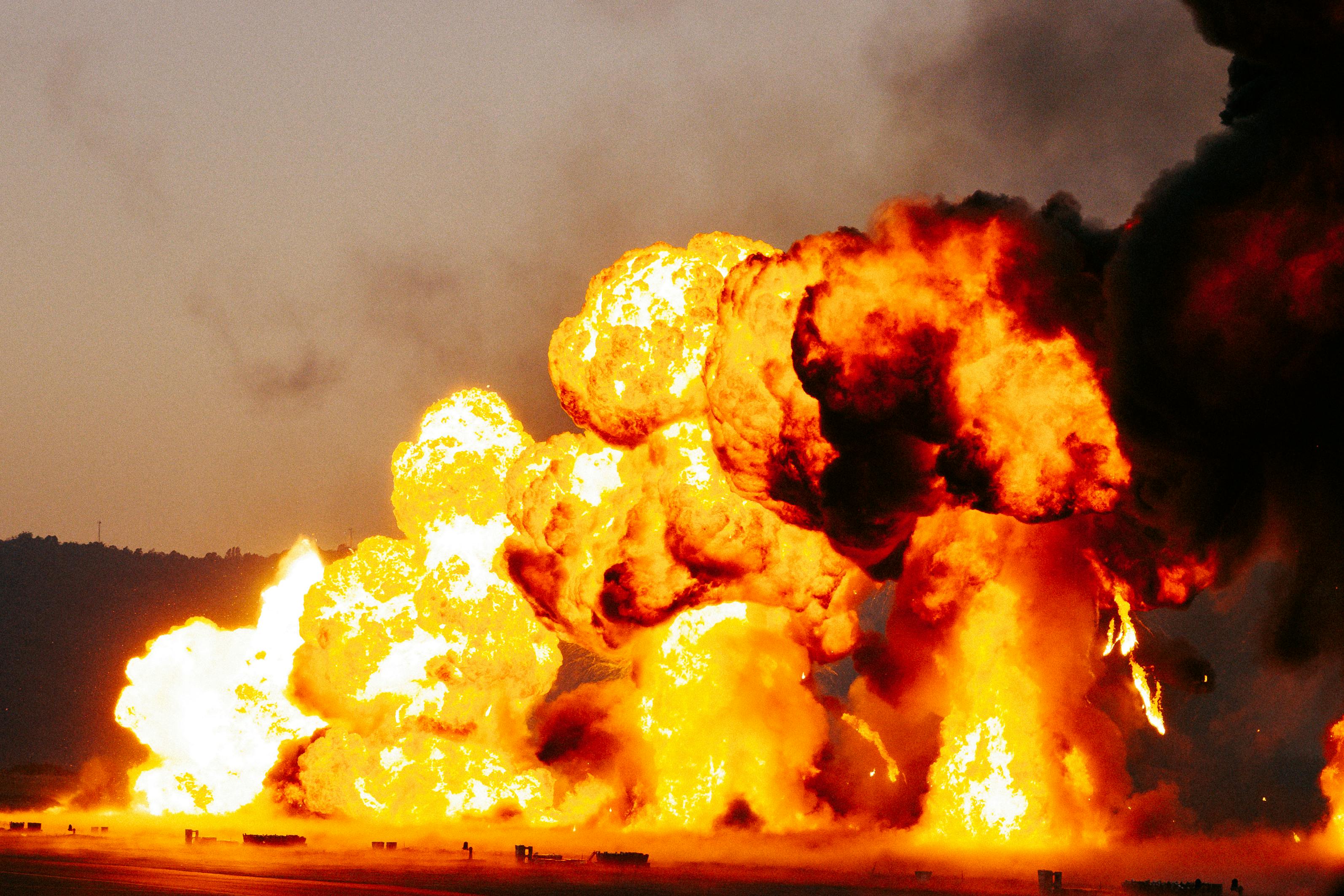 Powerful explosion with massive flames and smoke during daytime.