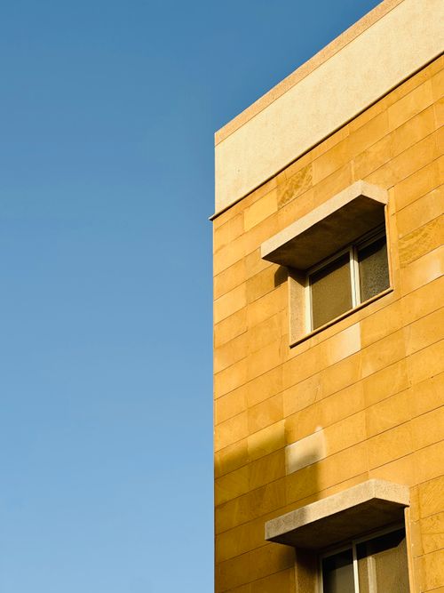 Free A modern residential building against a clear blue sky in Dubai. Stock Photo