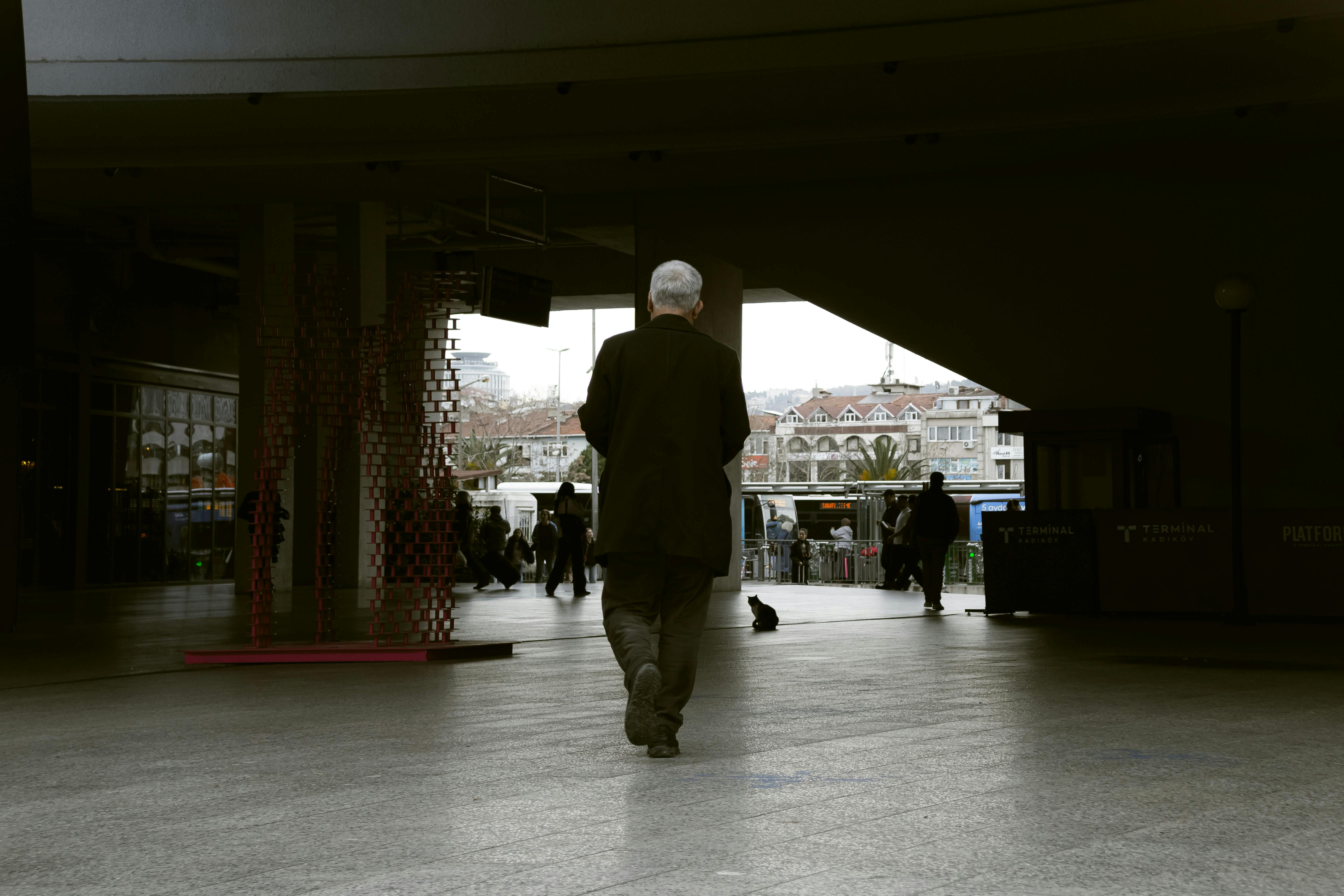 Gratis Eldre mann går gjennom en terminalpassasje i Istanbul, Tyrkia med bybilde i bakgrunnen. Arkivbilde