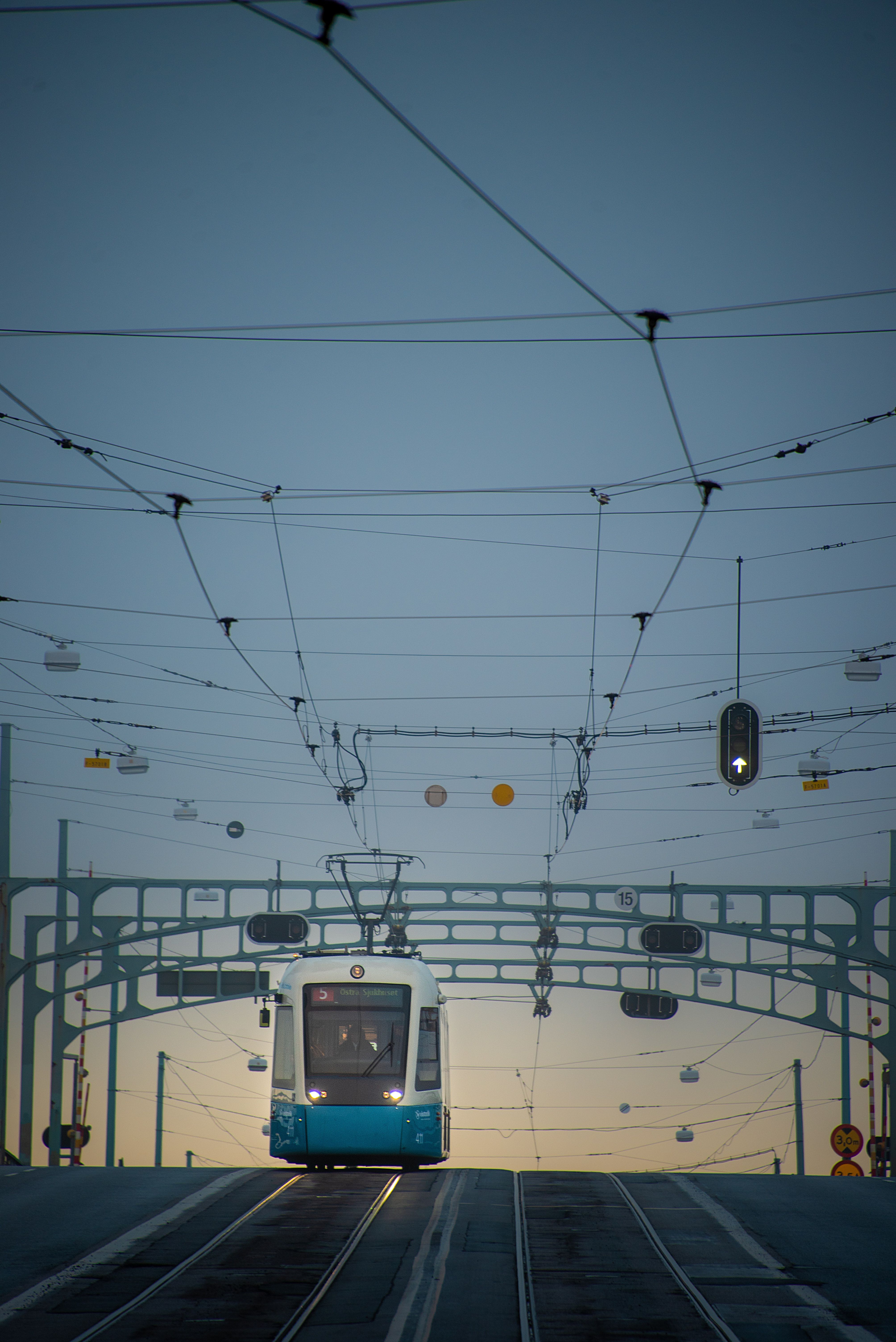 Tram crossing a bridge in Göteborg, Sweden at twilight, showcasing urban transportation and infrastructure.