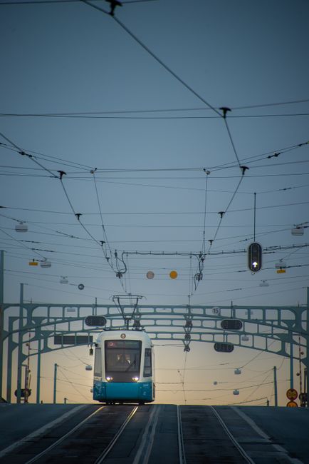 Tram crossing a bridge in Göteborg, Sweden at twilight, showcasing urban transportation and infrastructure.