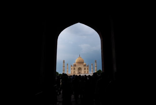 Free Silhouettes of people walking towards the Taj Mahal on a cloudy day in India. Stock Photo