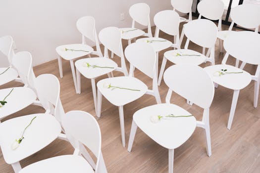 Minimalist wedding ceremony seating with white chairs and delicate flowers in Mexico City.