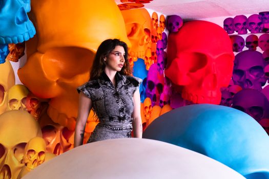 Woman poses with colorful skull art in Mexico City setting, showcasing vibrant aesthetic.