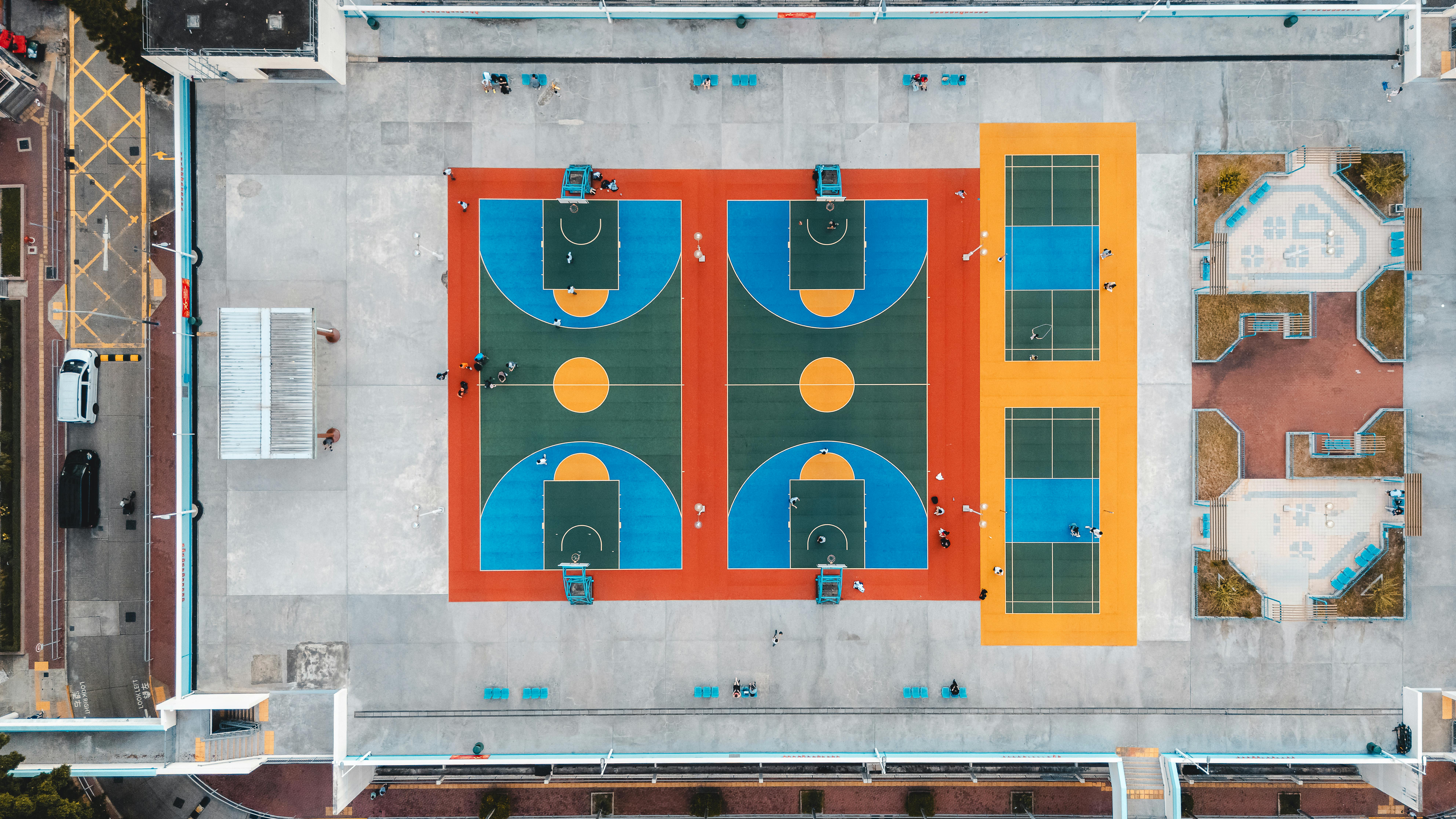 grátis Vista aérea das vibrantes quadras de basquete e tênis em Kowloon, Hong Kong, mostrando o lazer urbano. Foto profissional