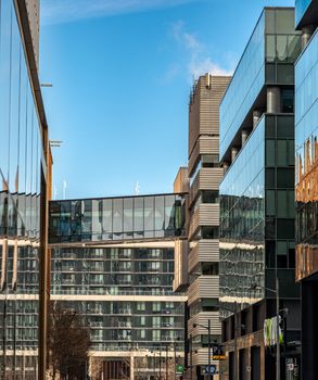 A view of contemporary glass and steel buildings in downtown Toronto, Ontario under a clear blue sky.