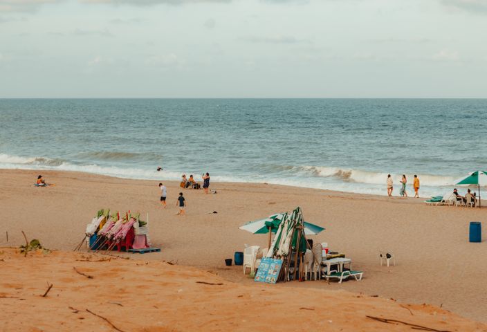 Relaxing beach scene with people enjoying a sunny day in RN, Brazil.