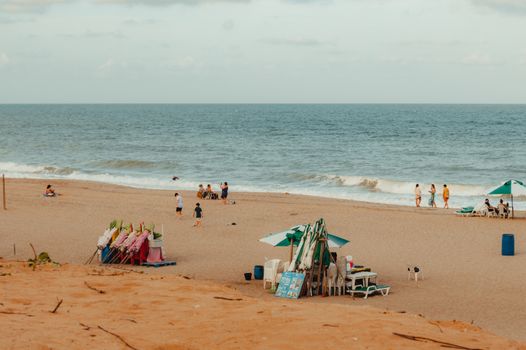 Relaxing beach scene with people enjoying a sunny day in RN, Brazil.