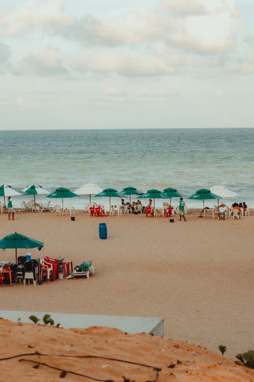 Free Relaxing beach view with umbrellas and people enjoying the summer in RN, Brasil. Stock Photo