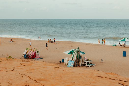 Sunny day at a picturesque beach in RN, Brazil with people enjoying the ocean and sand.
