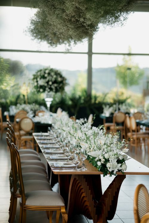 Free Beautifully arranged wedding reception with elegant floral centerpiece and natural lighting. Stock Photo