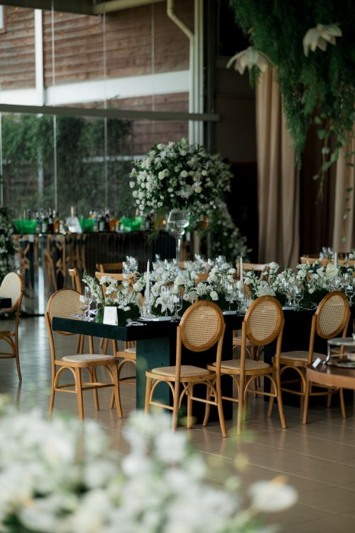 Free Beautifully decorated indoor wedding reception venue with floral arrangements and elegant table settings. Stock Photo