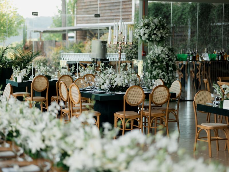 Sunlit venue decorated with floral arrangements and styled seating