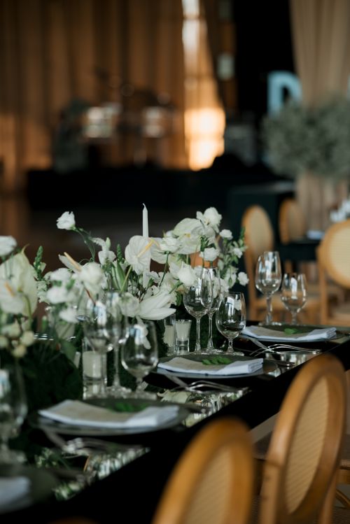 Free Elegant reception table with floral centerpiece and glassware, perfect for weddings. Stock Photo