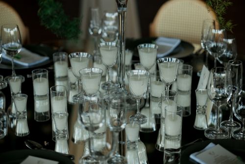Free A sophisticated table setup featuring candles in glass holders and elegant glassware, creating a warm, romantic ambiance. Stock Photo