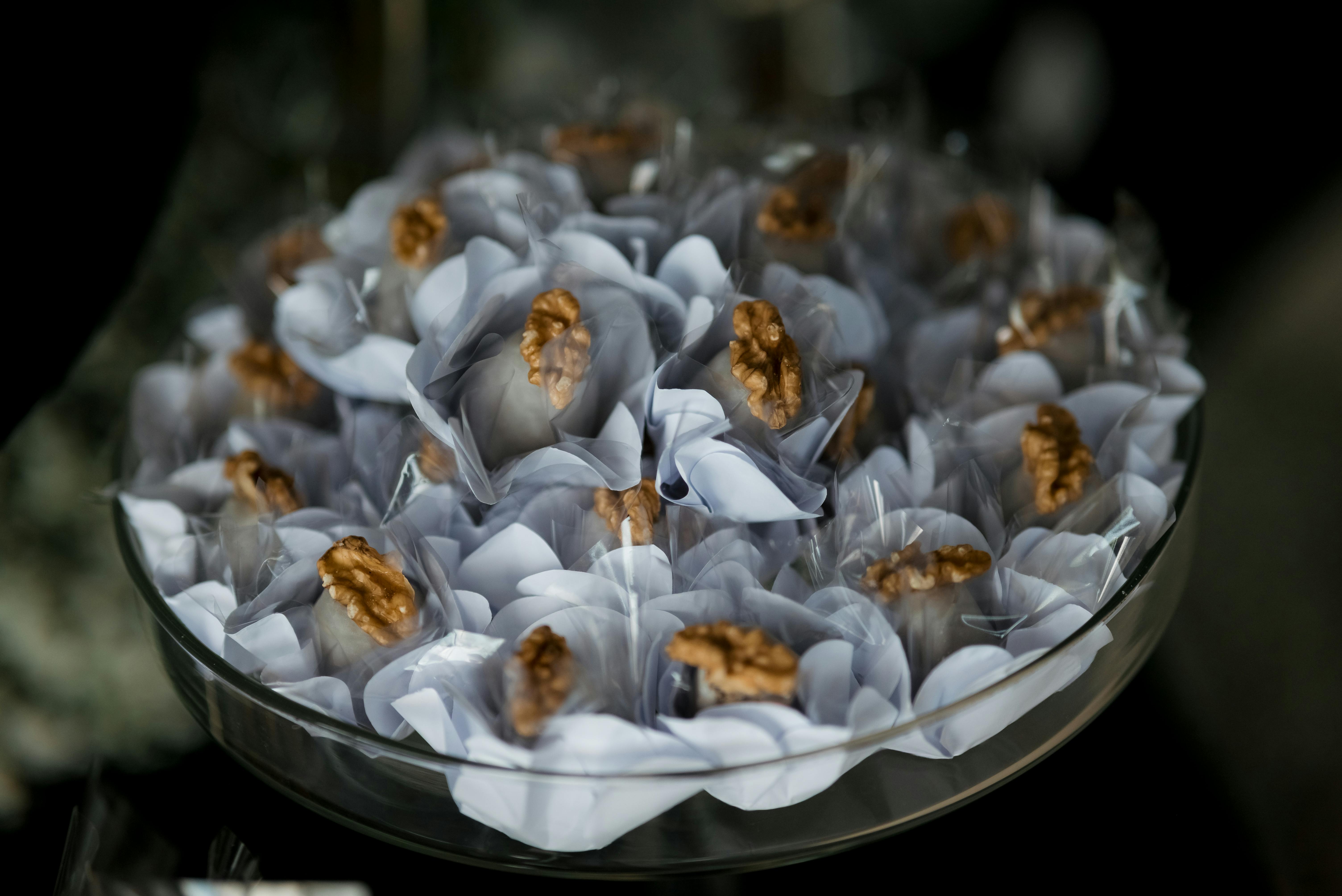 Безкоштовне Гарно викладена випічка з волоськими горіхами у білих обгортках на скляній тарілці. стокове фото