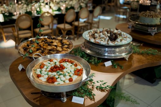 An elegant spread of tarts on a decorative buffet table at an indoor event.
