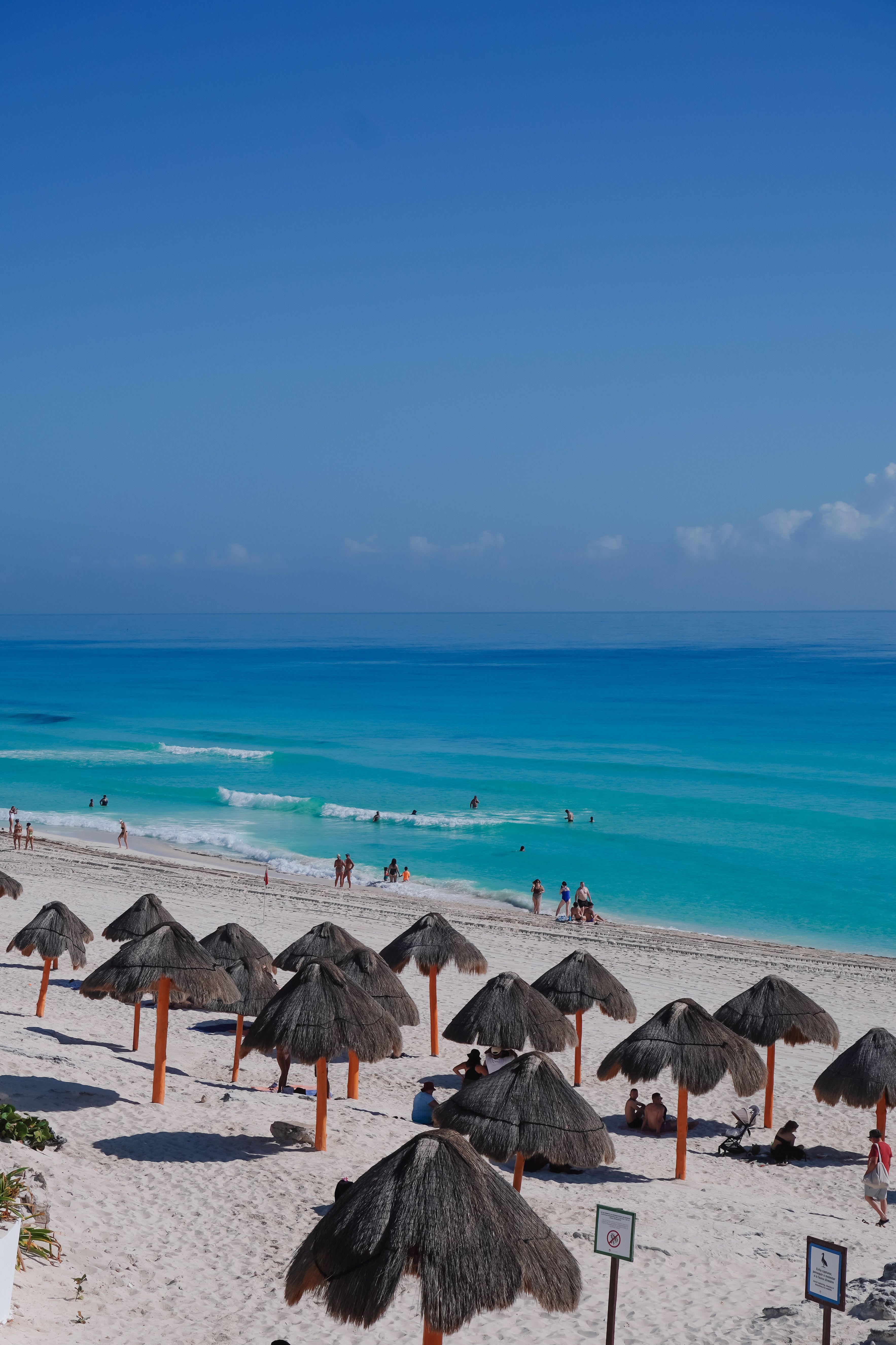 Parasols en chaume sur une plage de Cancún au Mexique avec une eau turquoise