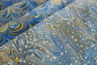 Swirled blue and gold marbled sheet — photo by betül nur akyürek on Pexels