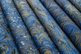 Rolled sheets of blue and gold marbled paper — photo by betül nur akyürek on Pexels