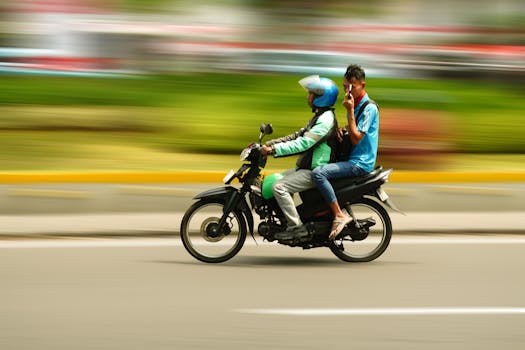 Two men riding a motorbike through a city, captured with motion blur for a dynamic effect.
