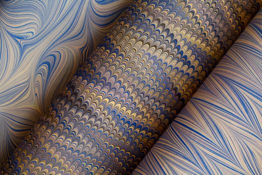 Close-up of elegant marbled paper showcasing intricate swirling patterns in blue and gold hues.