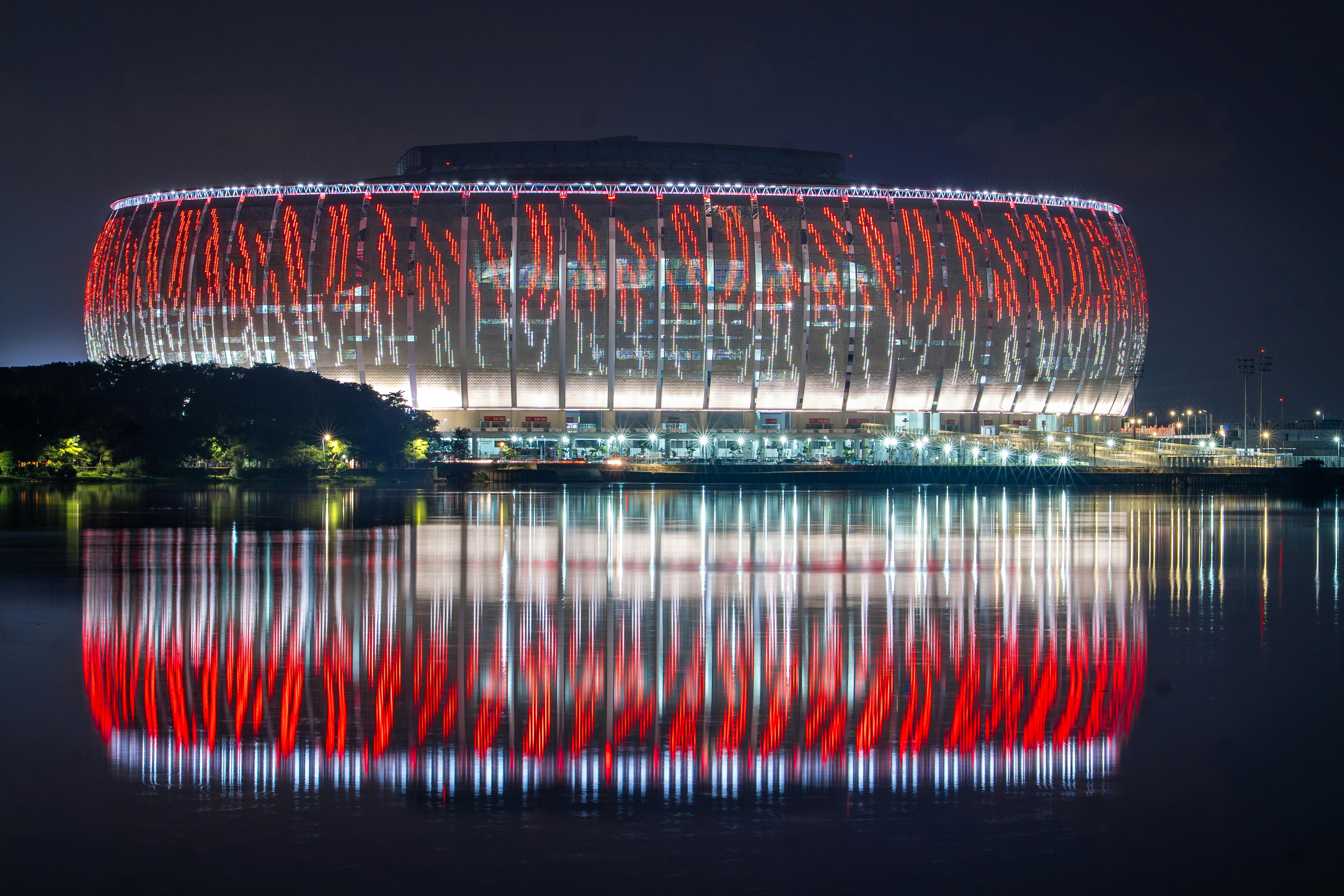 Lusail Stadium beautifully illuminated with reflections on water during night in Qatar.