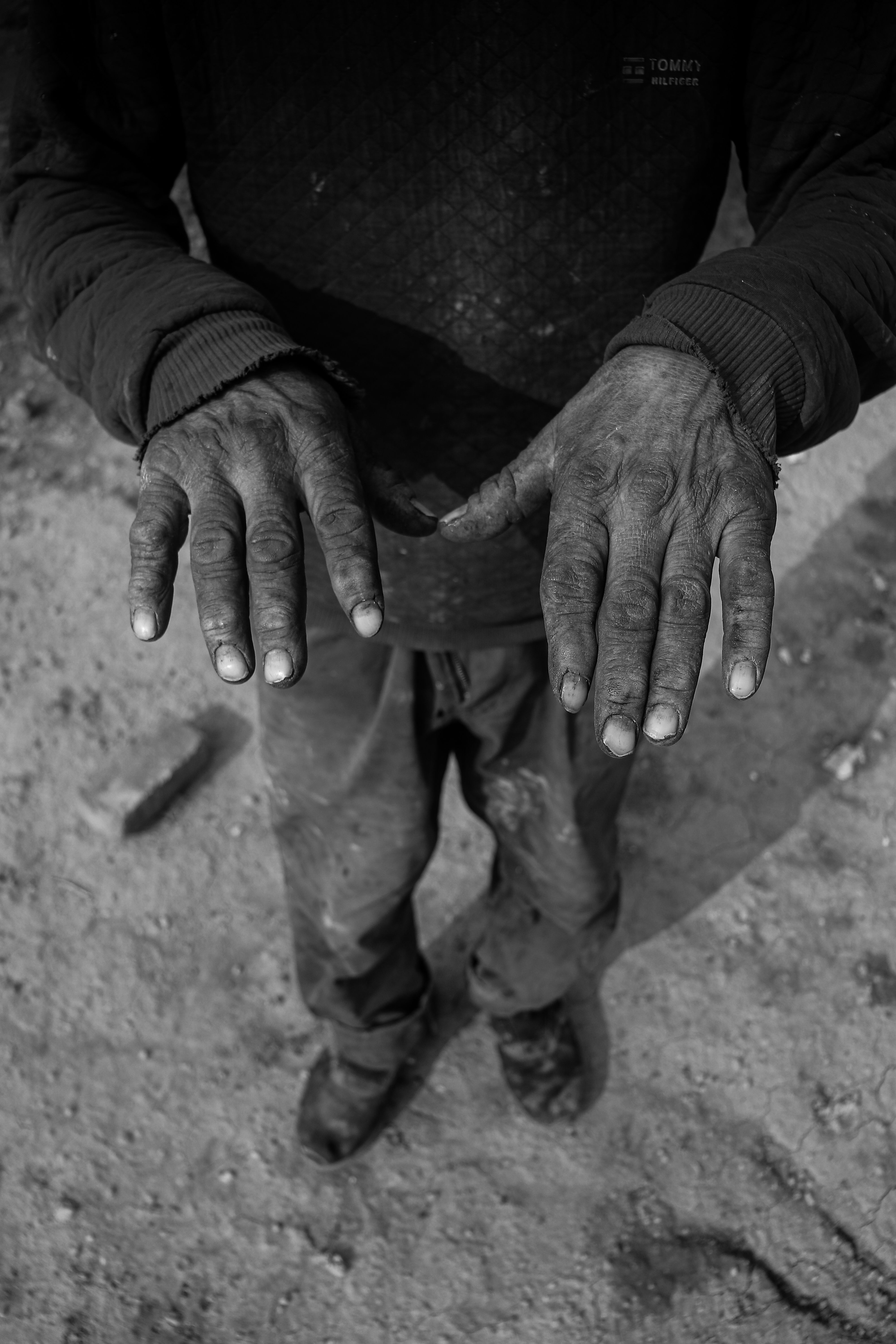 Close-up of dirty hands in a black and white portrait representing labor.