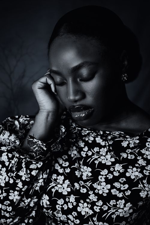 Free Emotive black and white portrait of a woman in a floral dress, evoking deep thought. Stock Photo