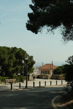 Serene view from Montjuïc Hill in Barcelona, featuring trees and cityscape.