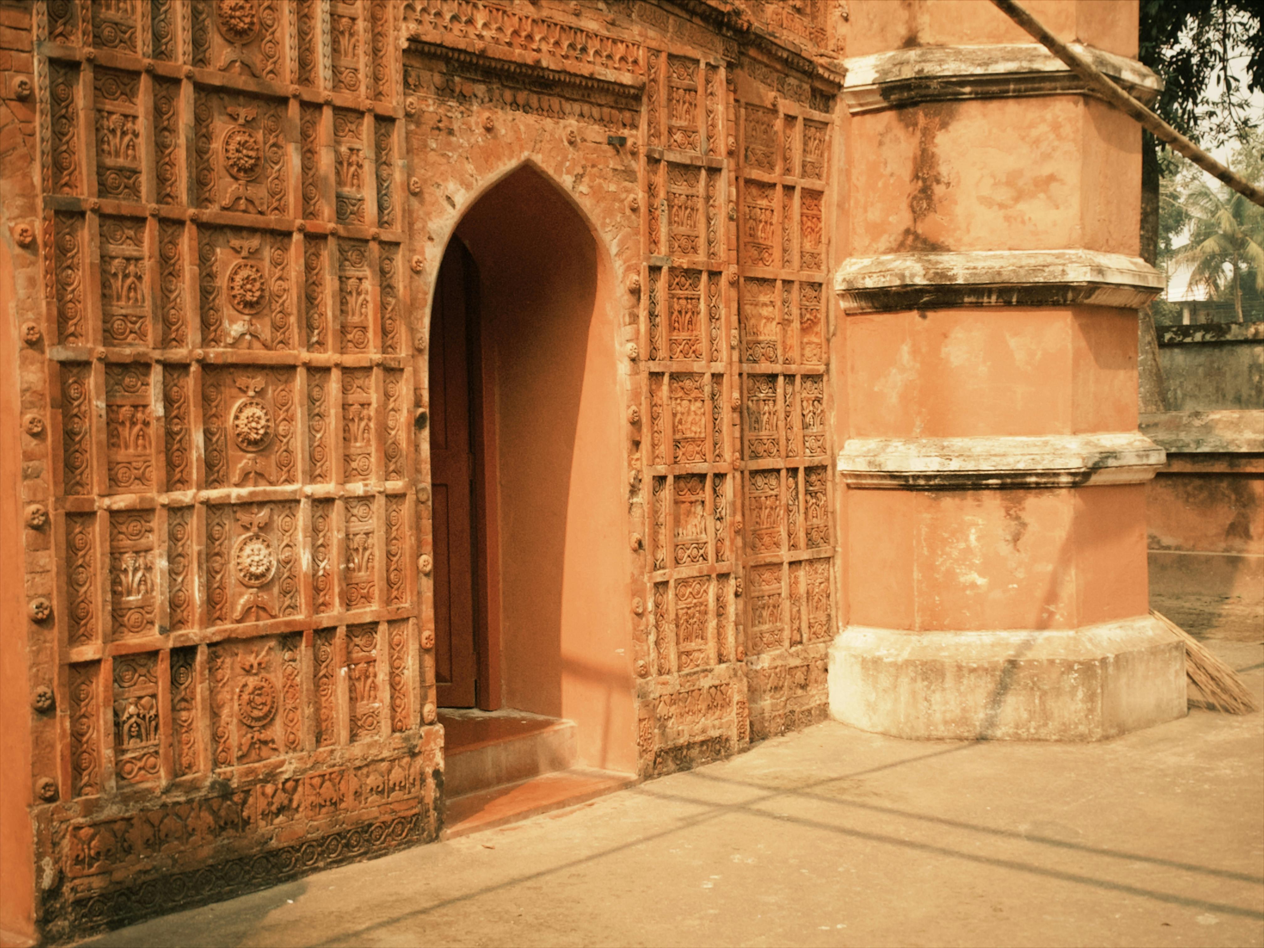 Gratis Facciata in terracotta dai colori vivaci che mette in mostra intricate incisioni su un edificio storico. Foto a disposizione