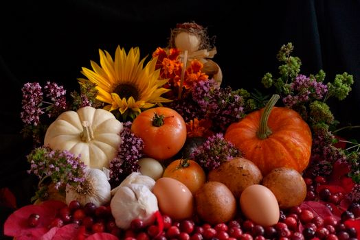 A rustic still life of autumn harvest featuring pumpkins, sunflowers, eggs, and seasonal flowers.