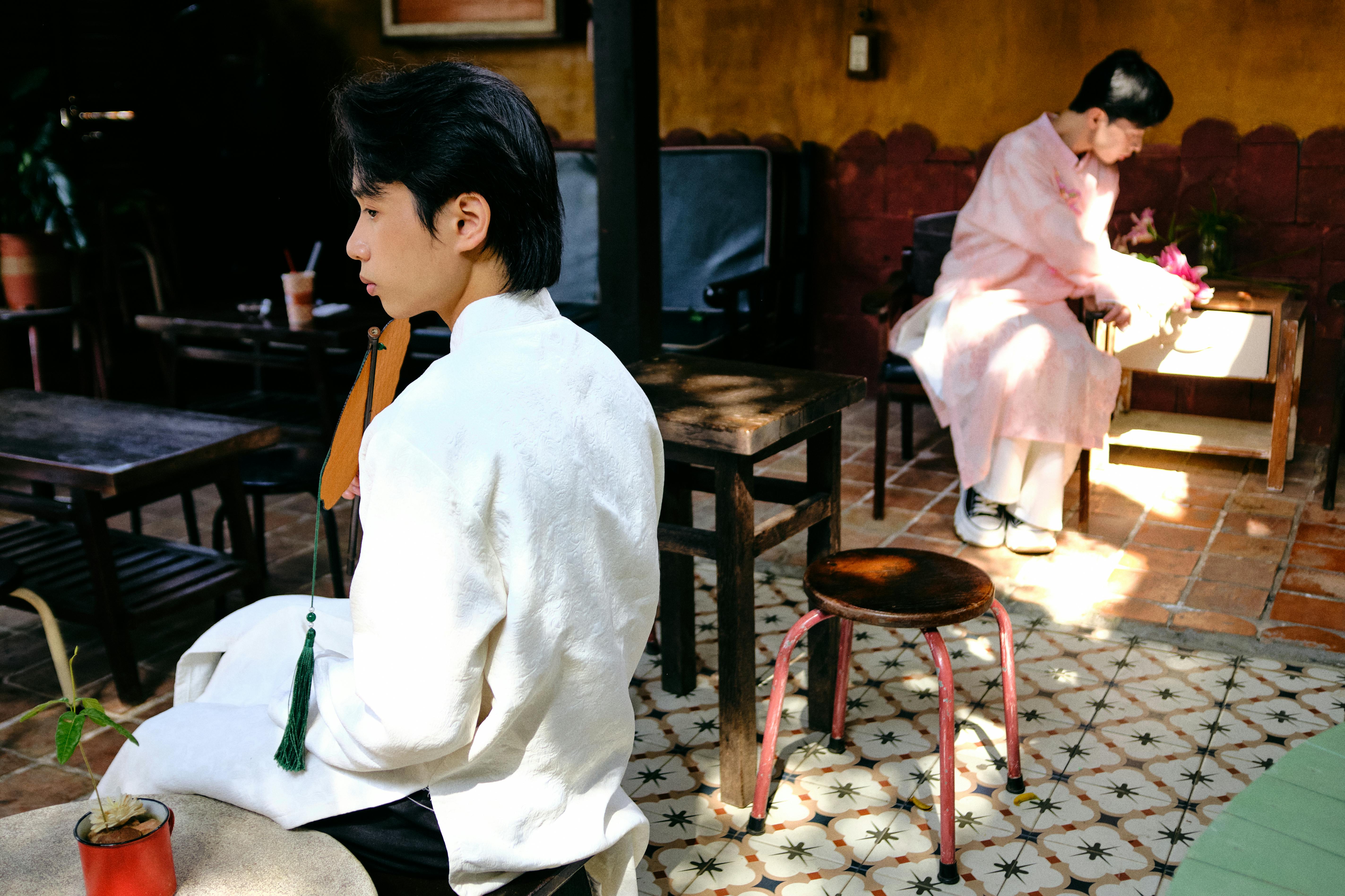 免费 在越南槟椥市的户外，两名身着传统奥黛的男子展现了文化的优雅。 素材图片