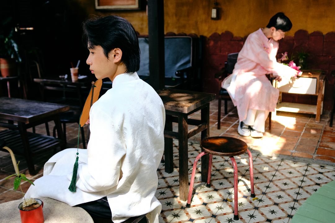 Two men wearing traditional Ao Dai in an outdoor setting in Bến Tre, Vietnam, capturing cultural elegance.
