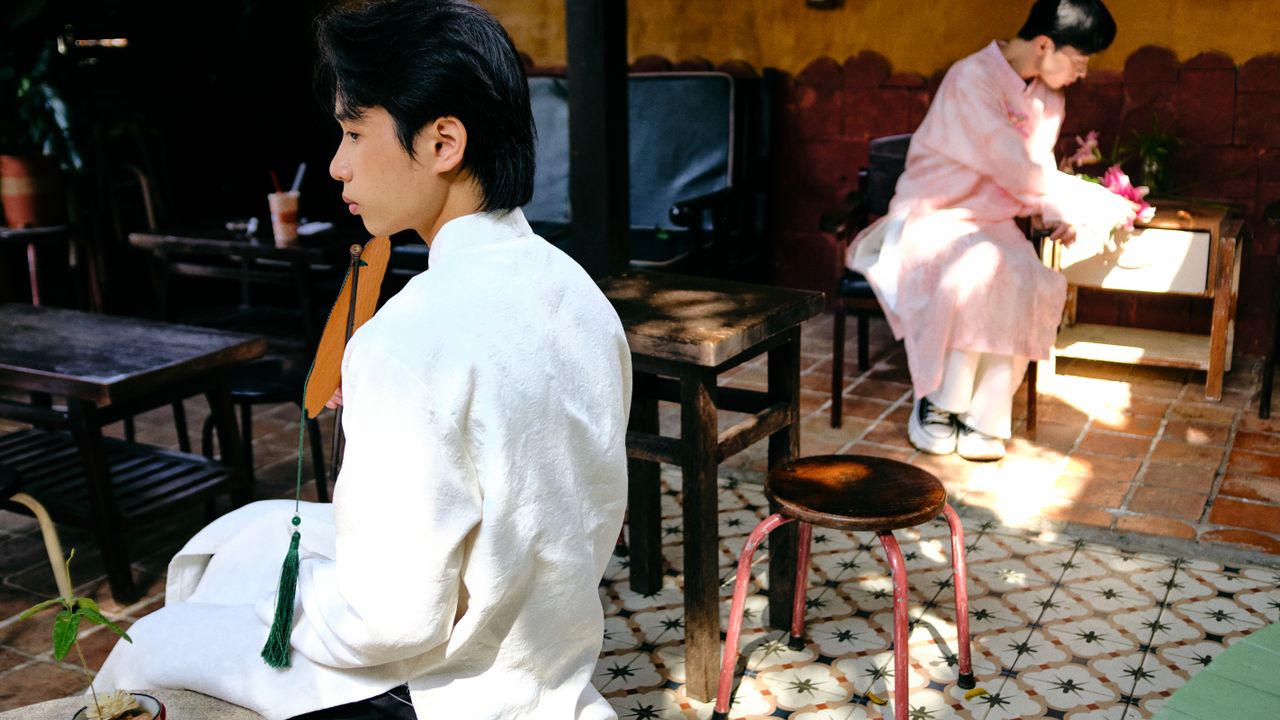 Two men wearing traditional Ao Dai in an outdoor setting in Bến Tre, Vietnam, capturing cultural elegance.