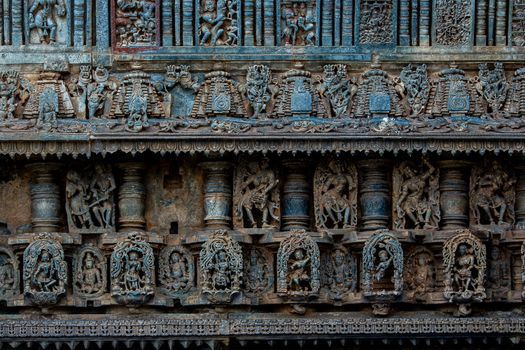 Detailed stone carvings depicting ancient mythology on an Indian temple facade.