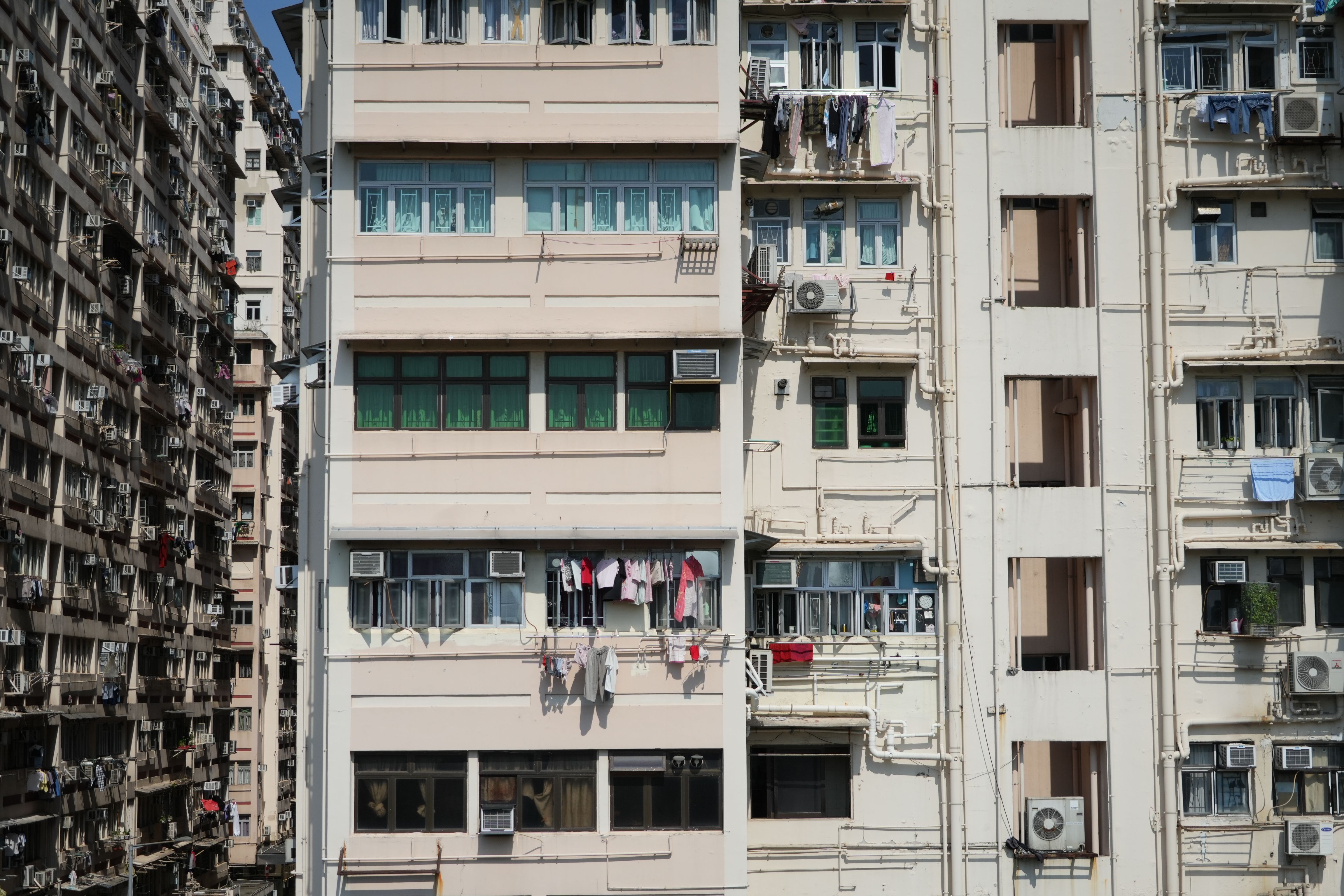 Densely packed Hong Kong residential buildings with weathered concrete facades