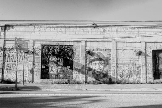 Monochrome image of graffiti and urban art on an abandoned building facade.