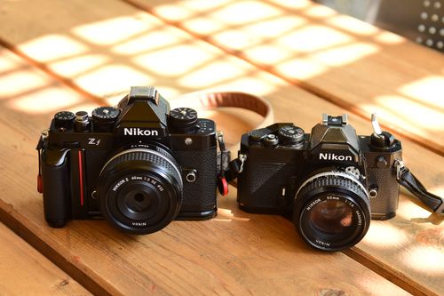Free Vintage Nikon cameras set on a wooden table with natural light. Stock Photo
