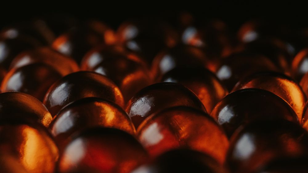 Macro study of glowing amber spheres against a dark background — photo by Vadim Timayev on Pexels